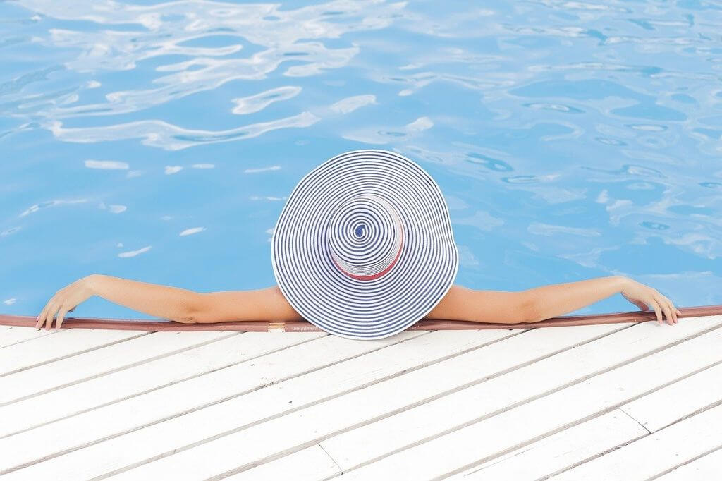 Woman in white hat relaxing in pool